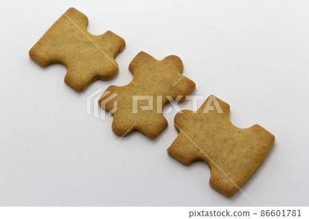 closeup of the jigsaw, puzzle shaped cookies white background, horizontal copy space pastry background. Team building, banner 86601781