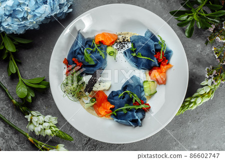 a stack of pancakes with salted salmon on a plate. Blue pancakes with salmon. Useful breakfast 86602747