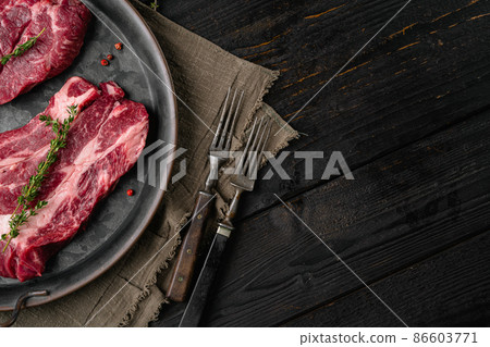 Fresh chuck roll steak, on black wooden table background, top view flat lay, with copy space for text 86603771