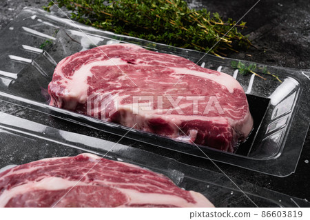 Fresh raw red meat vacuum sealed in plastic, on black dark stone table background Fresh raw red meat vacuum sealed in plastic, on black dark stone table background 86603819