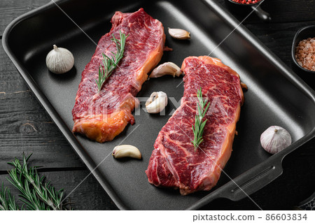 Fresh raw new-york steak, on black wooden table background Fresh raw new-york steak, on black wooden table background 86603834