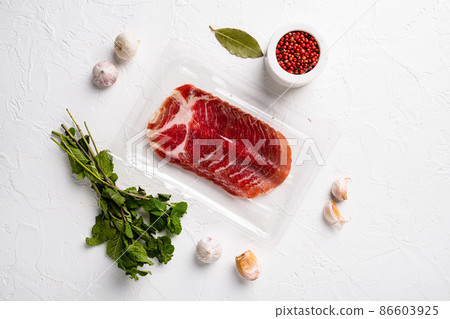 Vacuum packed cured coppa ham , on white stone table background, top view flat lay, with copy space for text Vacuum packed cured coppa ham , on white stone table background, top view flat lay, with copy space for text 86603925