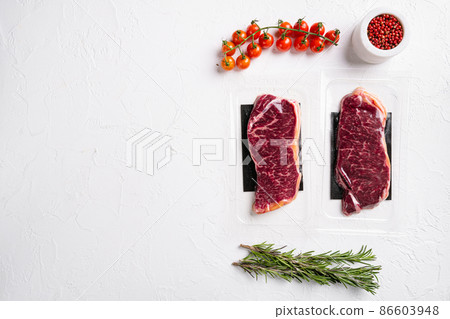 Vacuum packed Raw New York striploin beef steak, on white stone table background, top view flat lay, with copy space for text Vacuum packed Raw New York striploin beef steak, on white stone table background, top view flat lay, with copy space for text 86603948