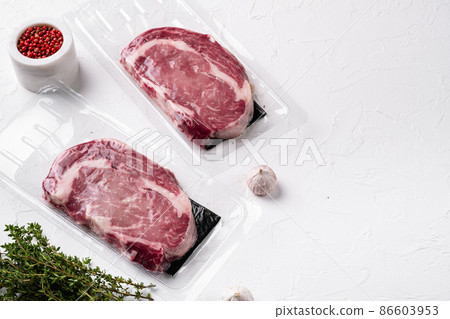 Fresh raw red meat vacuum sealed in plastic, on white stone table background, with copy space for text Fresh raw red meat vacuum sealed in plastic, on white stone table background, with copy space for text 86603953