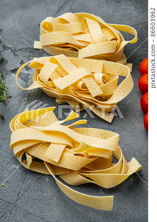 Raw pasta ingredient, on gray stone table background Raw pasta ingredient, on gray stone table background 86603962