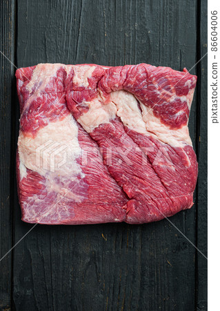 Raw brisket, beef brisket meat, on black wooden table background, top view flat lay, with copy space for text 86604006