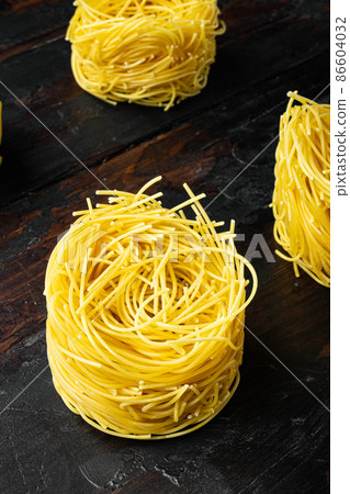 Durum wheat semolina homemade egg pasta tagliarini, on old dark wooden table Durum wheat semolina homemade egg pasta tagliarini, on old dark wooden table 86604032