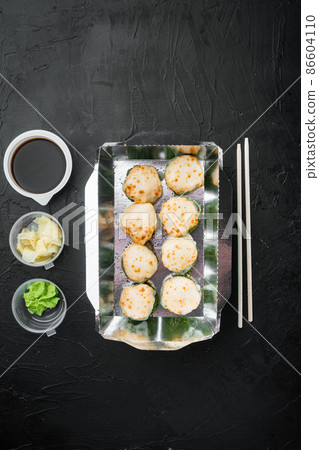 Sushi rolls in takeaway container, on black stone background, top view flat lay , with copyspace and space for text Sushi rolls in takeaway container, on black stone background, top view flat lay , with copyspace and space for text 86604110