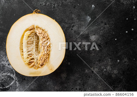 Slice of fresh melon, on black dark stone table background, top view flat lay, with copy space for text 86604156