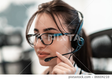 Business and technology concept - helpline female operator with headphones in call centre .Business woman with headsets working in a call center Business and technology concept - helpline female operator with headphones in call centre .Business woman with headsets working in a call center 86604210