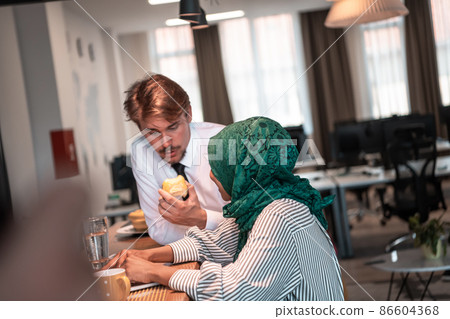 International multicultural business team.A young business man and woman sit in a modern relaxation space and talk about a new business. 86604368