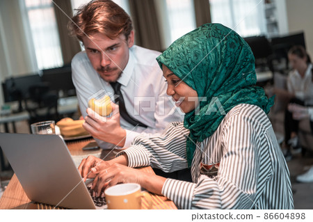 International multicultural business team.A young business man and woman sit in a modern relaxation space and talk about a new business. 86604898