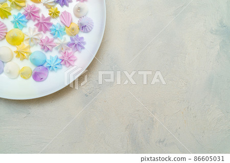 Closeup of part plate with delicious colorful meringue cookies. Sweet decor. Confectionery  86605031