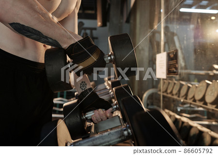 Man Taking Dumbbells from Stand Man Taking Dumbbells from Stand 86605792
