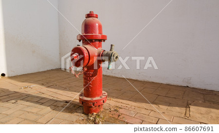 Red fire hydrant on a city street 86607691