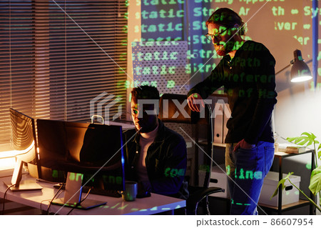 Two young intercultural program developers looking at computer screen 86607954