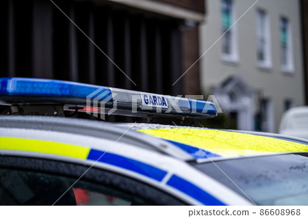 View of police emblems in Ireland, emblem on building, car, and street lantern View of police emblems in Ireland, emblem on building, car, and street lantern 86608968