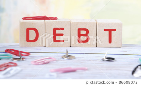 Debt text written on wooden cubes on a light colored background Debt text written on wooden cubes on a light colored background 86609072