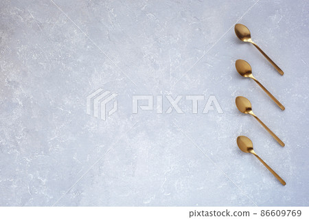 Golden spoons on grey background, flatlay, space for creating a list or plan 86609769