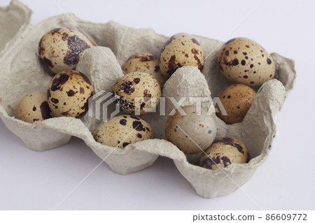 Quail eggs in a paper container closeup, side view 86609772