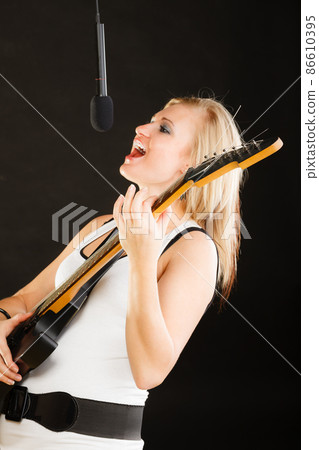 Woman playing on electric guitar and singing 86610395