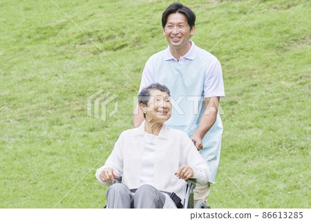 坐在輪椅上的老人與戶外護理人員 86613285