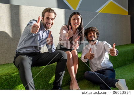 Group of young people feeling excited and cheerful in the lounge zone in the office Group of young people feeling excited and cheerful in the lounge zone in the office 86613854