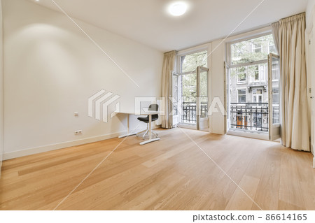 a set of stylish desk and an office chair in an empty room with balcony 86614165