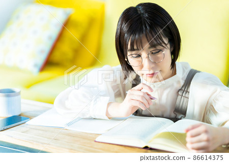 戴眼鏡在客廳學習的年輕女子 86614375
