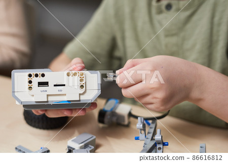 Kid Building Electric Robot Close Up 86616812
