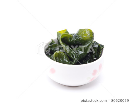 Seaweed wakame in ceramic bowl isolated on white background. Japanese food Seaweed wakame in ceramic bowl isolated on white background. Japanese food 86620059