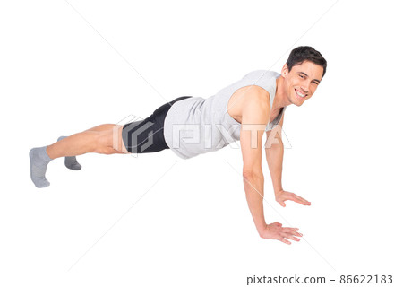 Positive sportsman doing push ups in studio 86622183