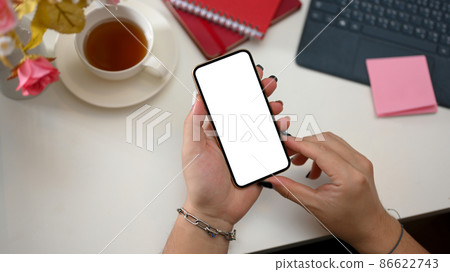 A smartphone white screen mockup in a female's hand A smartphone white screen mockup in a female's hand 86622743