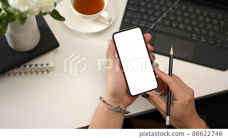 Female hands holding a smartphone white screen mockup. Female hands holding a smartphone white screen mockup. 86622746