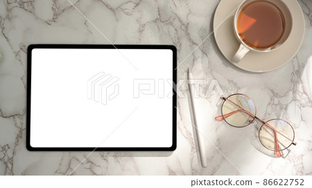 Feminine office desk with tablet blank screen mockup on marble background. Feminine office desk with tablet blank screen mockup on marble background. 86622752