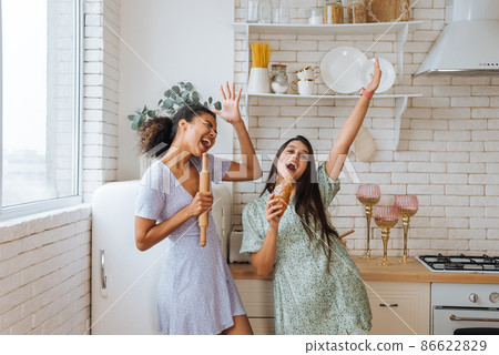 two girls of different races having fun in the kitchen 86622829
