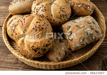 Wicker basket with selection of breads and pastries. Assortment of baked products Wicker basket with selection of breads and pastries. Assortment of baked products 86623007