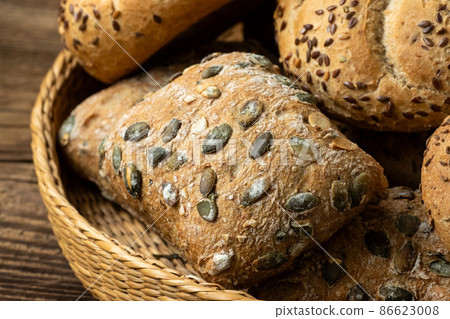 Wicker basket with selection of breads and pastries. Assortment of baked products 86623008