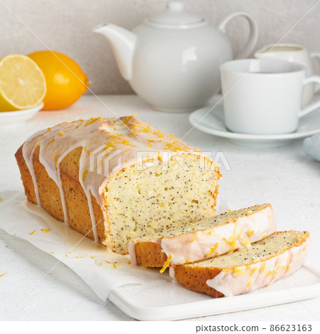 Lemon bread coated with sugar sweet icing and sprinkled with lemon peel. Slice of cake with citrus 86623163