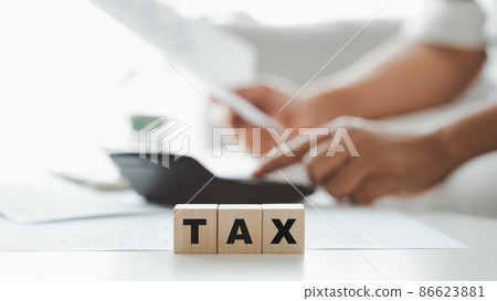 Woman is calculating annual tax, monthly expenses with calculator and filling form of Individual Income Tax Return. Season to pay Tax and Budget planning concept. 86623881