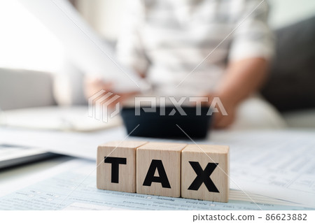 Woman is calculating annual tax, monthly expenses with calculator and filling form of Individual Income Tax Return. Season to pay Tax and Budget planning concept. 86623882