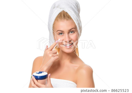 Beautiful laughing young woman with facial cream on her cheek Beautiful laughing young woman with facial cream on her cheek 86625523