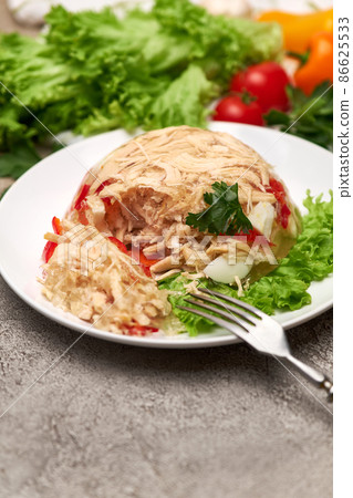 Delicious chicken aspic on a plate on concrete table Delicious chicken aspic on a plate on concrete table 86625533