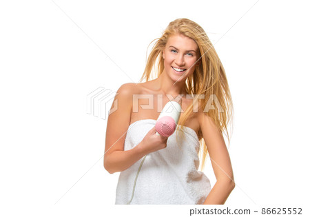 Young woman in towel dries hair a hairdryer Young woman in towel dries hair a hairdryer 86625552