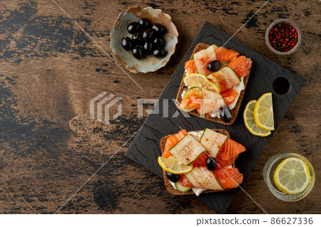 Smorrebrod - traditional Danish sandwiches. Black rye bread with salmon, cream cheese 86627336