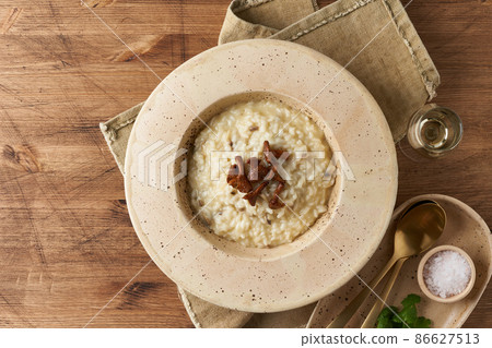 Risoto with chanterelle mushrooms in large plate. Traditional italian dish. Top view, copy space 86627513