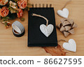 notebook with black sheets with copy space, bouquet of flowers and a white heart. 86627595