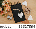 notebook with black sheets with copy space, bouquet of flowers and a white heart. 86627596