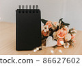 notebook with black sheets with copy space, bouquet of flowers and a white heart. 86627602