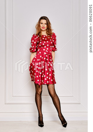 Portrait of young woman in dotted satin dress and polka dot tights 86628091